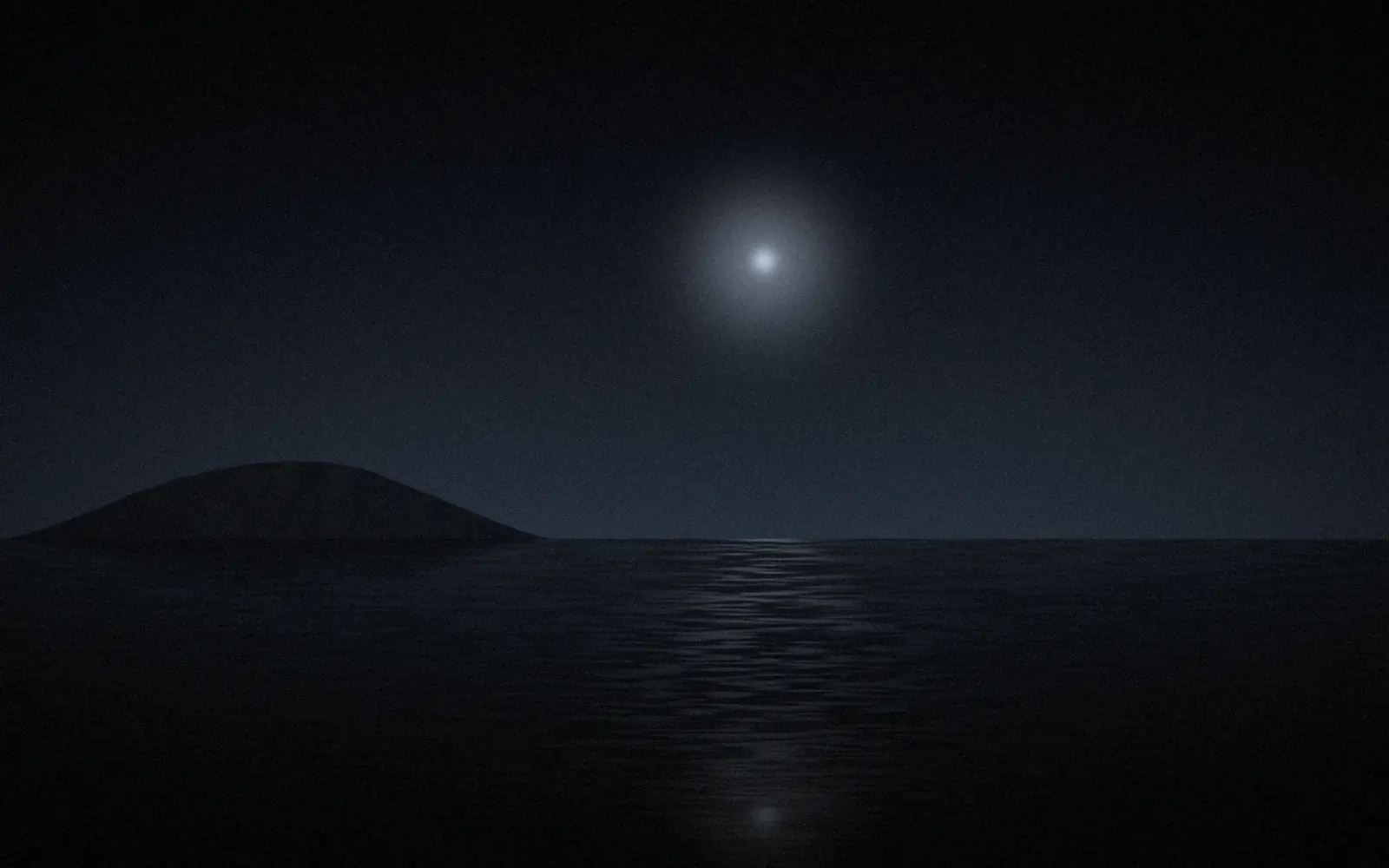 A dark coastline under a pale moon